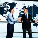 A diverse group of multinational business professionals in modest business attire, standing in a sleek, modern office space with a large digital world map displayed on a transparent screen, showing illuminated connection lines between different continents. They are engaged in a confident, natural pose, symbolizing global collaboration and seamless communication. High-quality professional photography, perfect anatomy, correct proportions, well-formed hands, proper finger count, natural body proportions, crisp focus, excellent lighting. safe for work, appropriate content, fully clothed, professional, family-friendly.